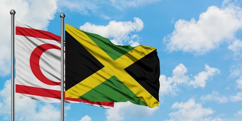 Northern Cyprus and Jamaica flag waving in the wind against white cloudy blue sky together. Diplomacy concept, international relations.