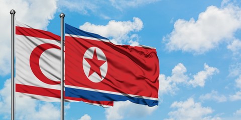 Northern Cyprus and North Korea flag waving in the wind against white cloudy blue sky together. Diplomacy concept, international relations.