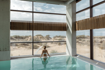 Girl relaxing in luxury swimming pool in modern hotel