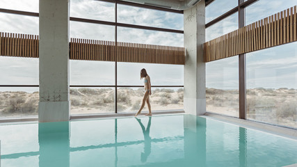 Girl relaxing in luxury swimming pool in modern hotel