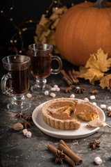 Yellow pumpkin pie orange  pumpkins with yelllow dry autumn leaves decor on dark table background.Harvesting,autumn and Thanksgiving concept