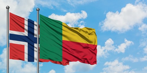 Norway and Benin flag waving in the wind against white cloudy blue sky together. Diplomacy concept, international relations.