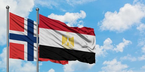 Norway and Egypt flag waving in the wind against white cloudy blue sky together. Diplomacy concept, international relations.