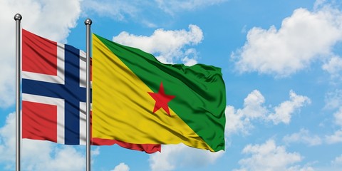 Norway and French Guiana flag waving in the wind against white cloudy blue sky together. Diplomacy concept, international relations.