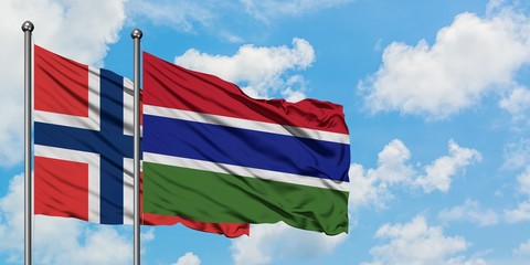 Norway and Gambia flag waving in the wind against white cloudy blue sky together. Diplomacy concept, international relations.