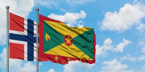Norway and Grenada flag waving in the wind against white cloudy blue sky together. Diplomacy concept, international relations.
