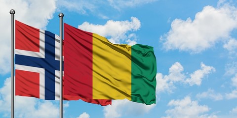 Norway and Guinea flag waving in the wind against white cloudy blue sky together. Diplomacy concept, international relations.