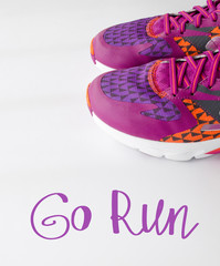 Go run, inspirational quote. Sport sneakers isolated on the white background. Sport concept. Accessories for fitness and running. Banner with handwritten lettering. Motivation