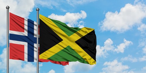 Norway and Jamaica flag waving in the wind against white cloudy blue sky together. Diplomacy concept, international relations.