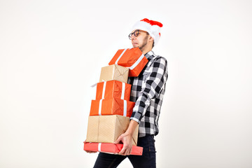 Holidays and presents concept - Funny man in Christmas hat holding many gift boxes on white background with copy space