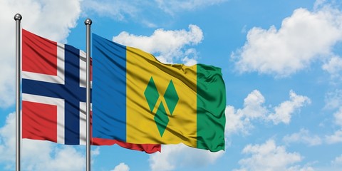 Norway and Saint Vincent And The Grenadines flag waving in the wind against white cloudy blue sky together. Diplomacy concept, international relations.