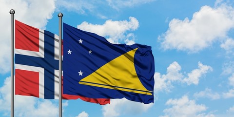 Norway and Tokelau flag waving in the wind against white cloudy blue sky together. Diplomacy concept, international relations.
