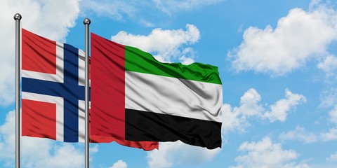 Norway and United Arab Emirates flag waving in the wind against white cloudy blue sky together. Diplomacy concept, international relations.