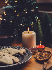 homemade christmas cookies and a chocolate cup, cinnamon, spice, candles and christmas tree on background. Cosy atmosphere 3