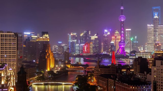 Timelapse modern Shanghai Waibaidu Bridge over Wusong river reflecting buildings and famous Chinese flashing TV tower illumination at night