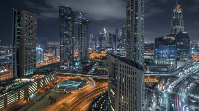 Aerial view of new towers and tall buildings with busy roads night timelapse in Dubai Downtown from above with traffic on highway and financial district on background, Dubai, United Arab Emirates