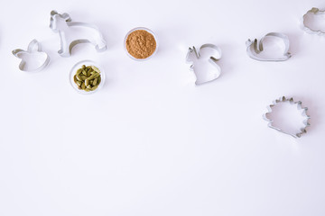 Animal cookie cutters on white table, top view. Cinammon and cardamom spice. Space for text, copy-space. 