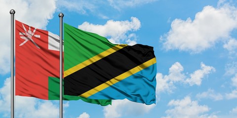 Oman and Tanzania flag waving in the wind against white cloudy blue sky together. Diplomacy concept, international relations.