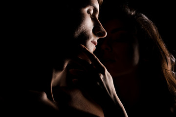 beautiful sexy couple hugging, isolated on black with backlight