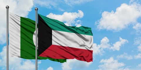 Pakistan and Kuwait flag waving in the wind against white cloudy blue sky together. Diplomacy concept, international relations.