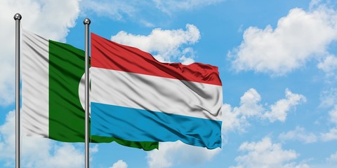 Pakistan and Luxembourg flag waving in the wind against white cloudy blue sky together. Diplomacy concept, international relations.
