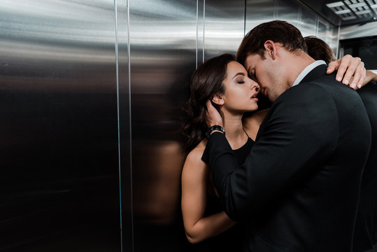 beautiful passionate couple hugging and going to kiss in lift