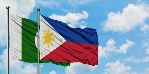 Pakistan and Philippines flag waving in the wind against white cloudy blue sky together. Diplomacy concept, international relations.