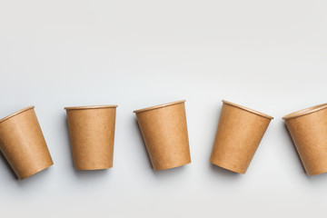 Vasos de cartón papel sobre fondo liso gris. Concepto reciclable. Vista superior y de cerca. Copy space - obrazy, fototapety, plakaty