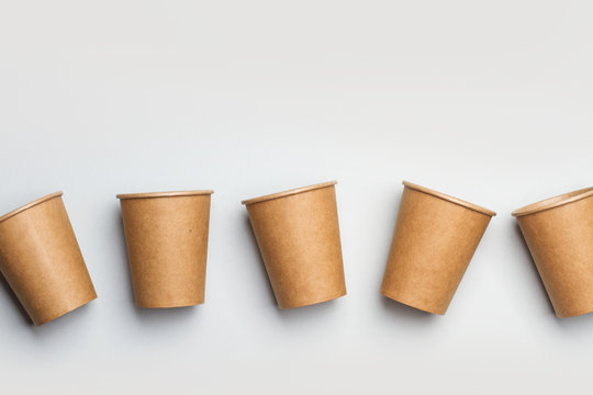 Vasos de cart&oacute;n papel sobre fondo liso gris. Concepto reciclable. Vista superior y de cerca. Copy space