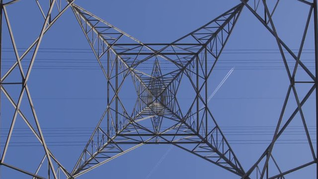 high voltage pylon against blue sky