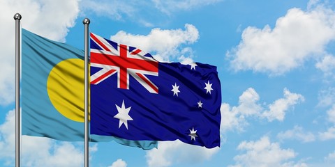 Palau and Australia flag waving in the wind against white cloudy blue sky together. Diplomacy concept, international relations.