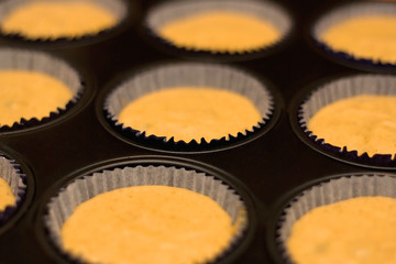 Cupcake mixture in a tray, ready for baking. Selective focus.