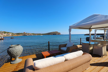 Sessel in einem Strandrestaurant am Cape Sounio Beach mit Blick auf den Poseidon Tempel in Griechenland