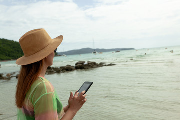 Fototapeta premium asian girls hold coconut beach walks on vacations, turquoise sea, bright sky and white clouds (concept travel holiday)
