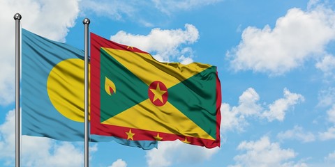 Palau and Grenada flag waving in the wind against white cloudy blue sky together. Diplomacy concept, international relations.