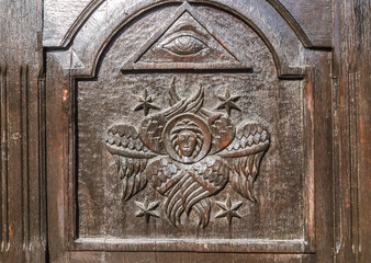 Carved angel with wings on old wooden door. The entrance to the church