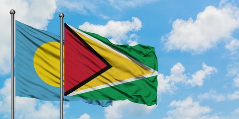 Palau and Guyana flag waving in the wind against white cloudy blue sky together. Diplomacy concept, international relations.