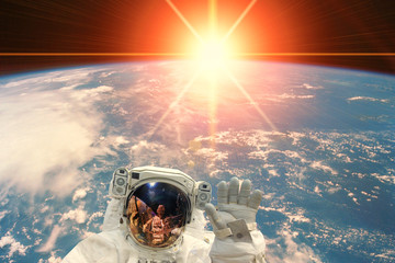 Obraz na płótnie Canvas Astronaut and sunrise. The elements of this image furnished by NASA.