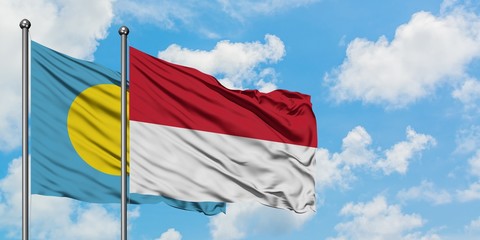 Palau and Indonesia flag waving in the wind against white cloudy blue sky together. Diplomacy concept, international relations.