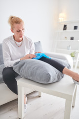 Obraz premium Injured woman holding ice pack / bag for cooling down the knee pain.
