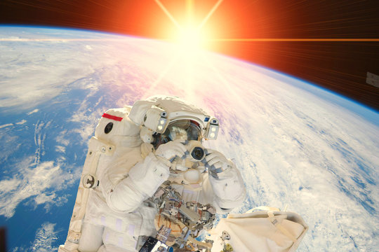 Astronaut and sunrise. The elements of this image furnished by NASA.