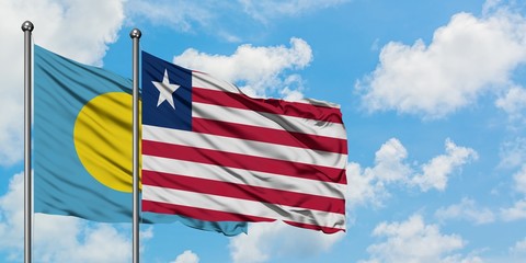 Palau and Liberia flag waving in the wind against white cloudy blue sky together. Diplomacy concept, international relations.