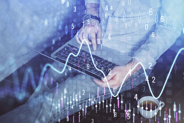 Forex graph with businessman working on computer in office on background. Concept of analysis. Double exposure.