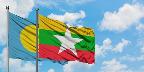 Palau and Myanmar flag waving in the wind against white cloudy blue sky together. Diplomacy concept, international relations.