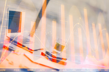Forex graph hologram on table with computer background. Multi exposure. Concept of financial...