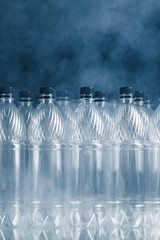 empty plastic bottles on black background with smoke, pollution concept