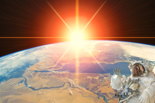 Astronaut and sunrise. The elements of this image furnished by NASA.