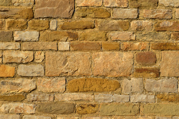 Old medieval yellow stone block wall as background