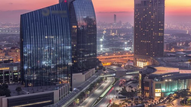 Dubai downtown street with busy traffic and skyscrapers around night to day transition timelapse. Modern road and urban buildings with mall aerial view. Sheikh Mohammed bin Rashid Blvd