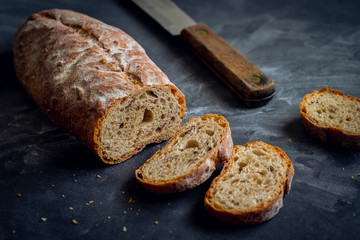 Bread loaf sliced on dark background